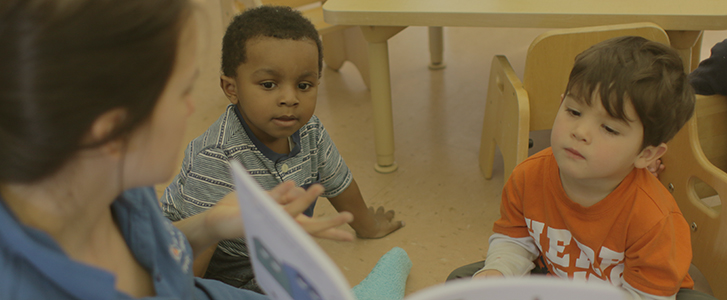 Teacher reading book to children